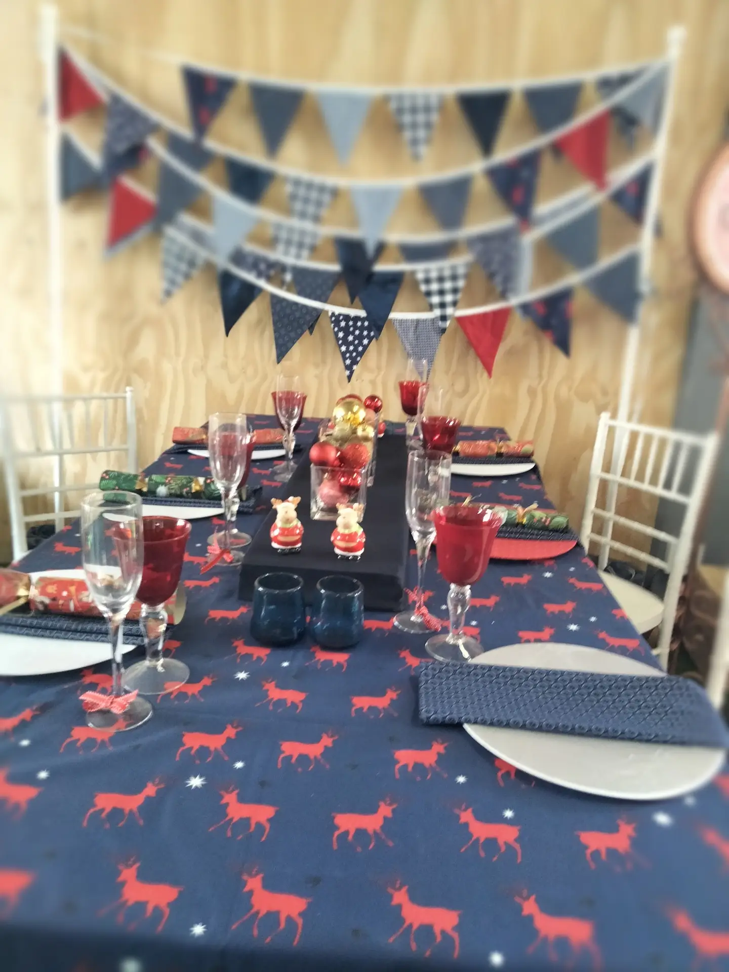 Festive table with navy deer-patterned cloth and colorful bunting