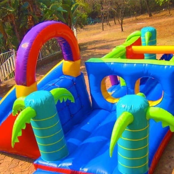 Bright inflatable play structure with palm trees.