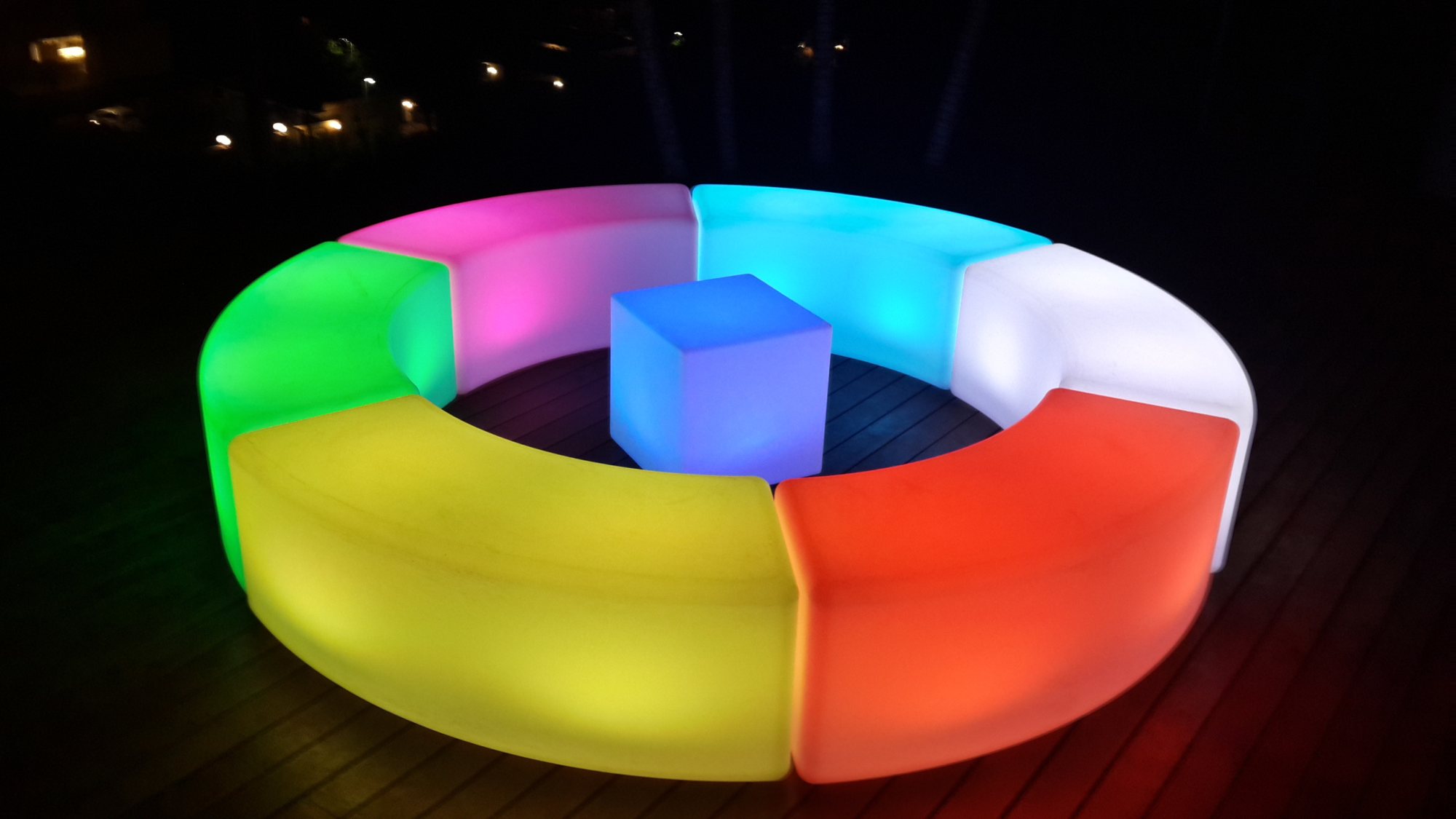 Colorful LED seating arrangement with a central cube table.