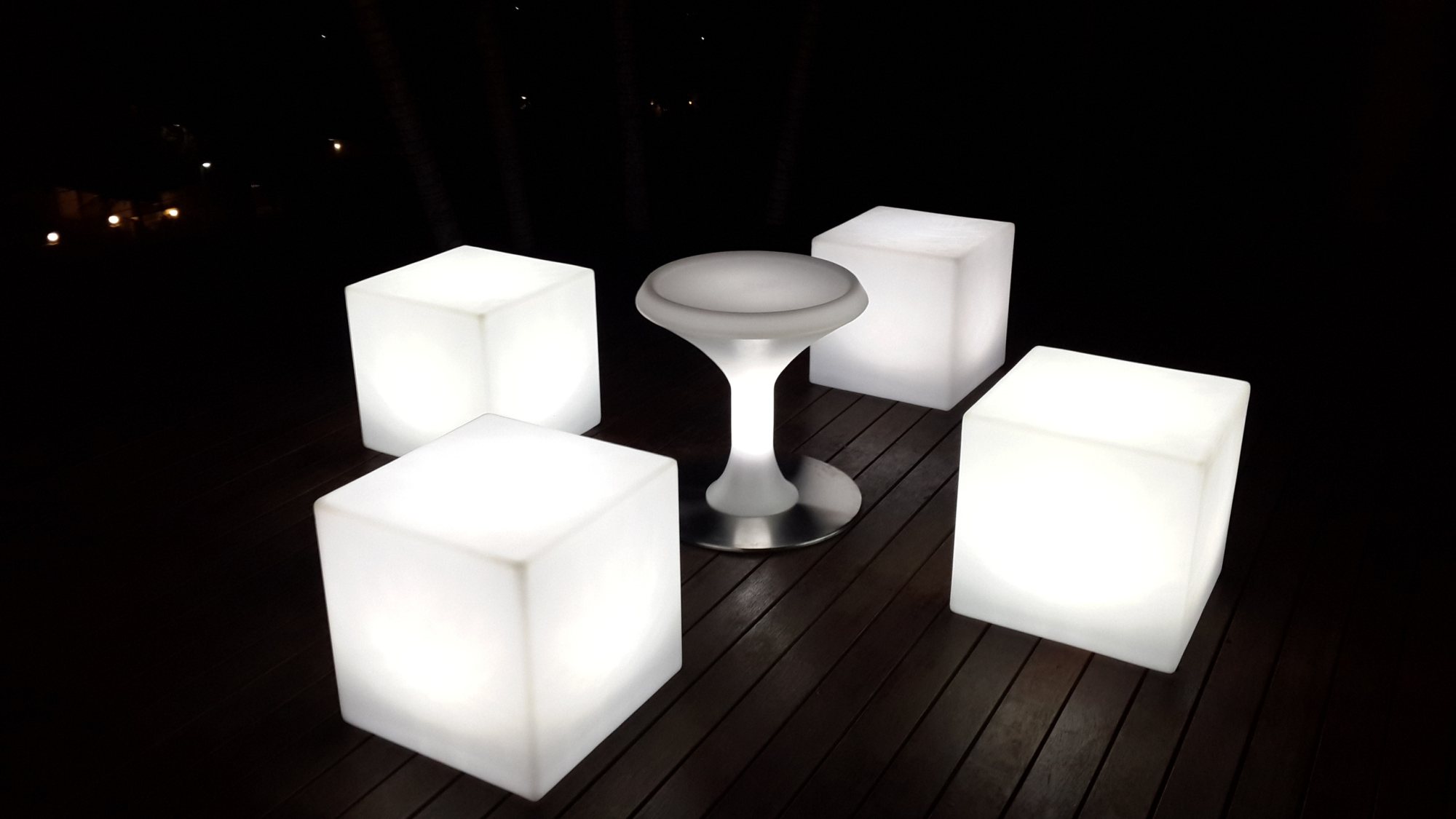 Illuminated cubes and stool on a wooden deck