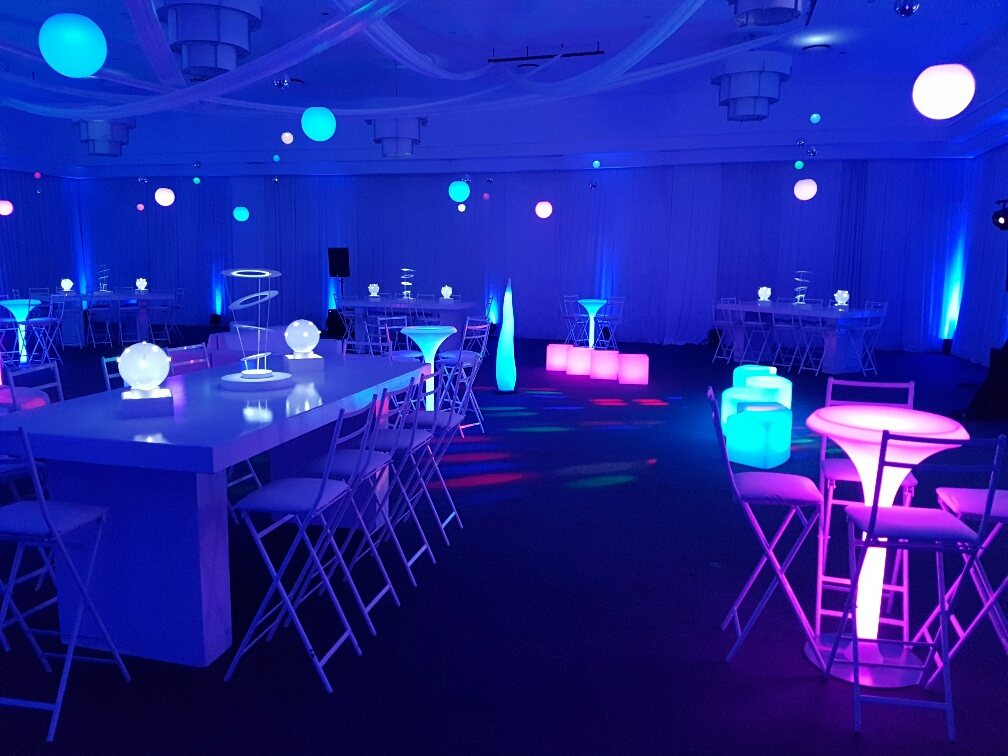 Event space with illuminated tables and colorful ambient lighting
