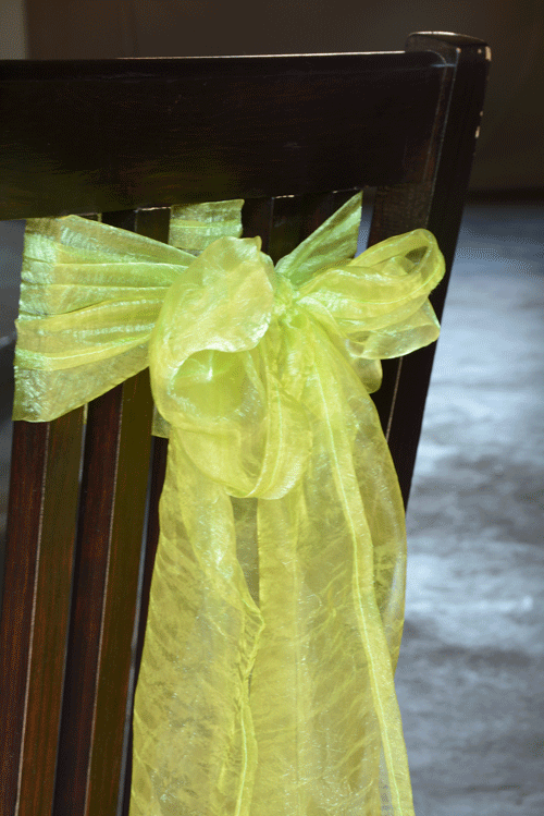 Lime green organza sash tied on a wooden chair