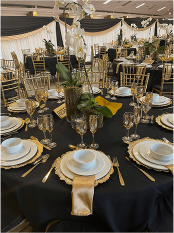 Table setting with black linen, gold accents, and floral centerpiece