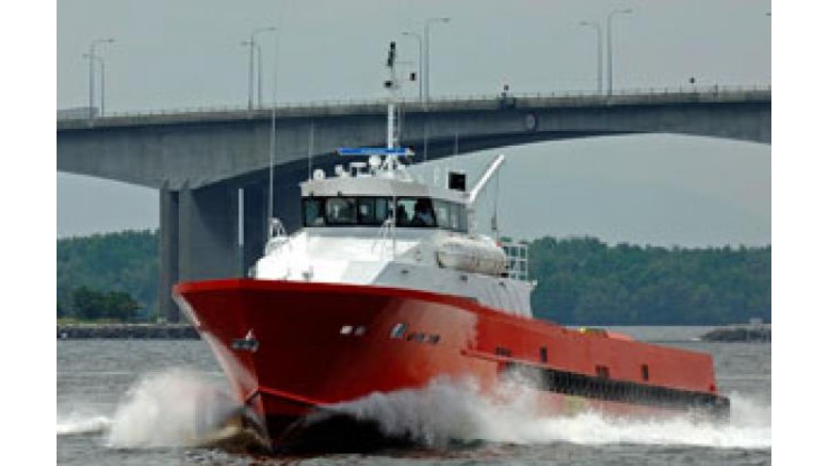 Red and white boat navigating on Johannesburg waters under a bridge.