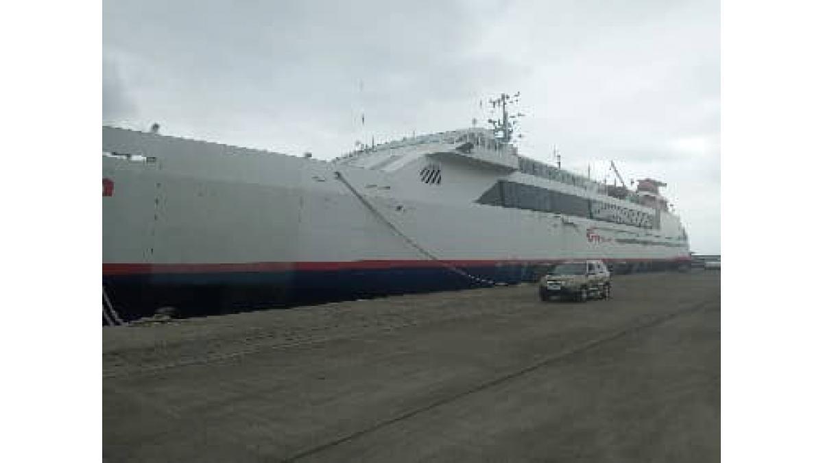 A large ship docked with equipment in view for event setup