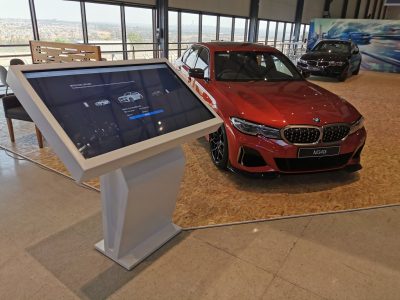 Interactive display near a red BMW car