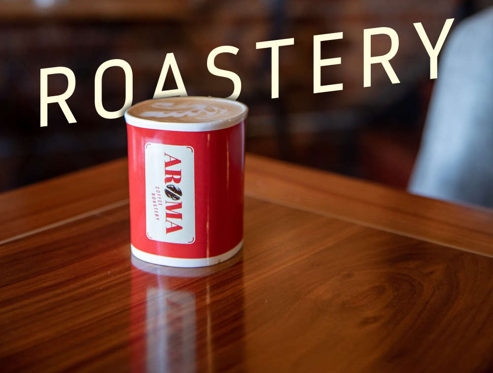 Branded Aromacoffee cup on a wooden table