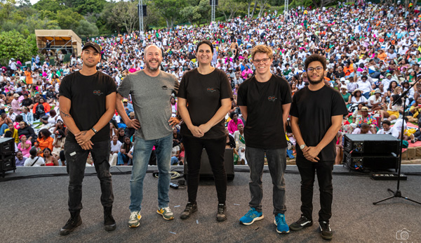 Five-member audio engineering team in a live event setting.