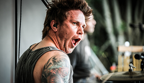 Drummer performing live with focused expression.