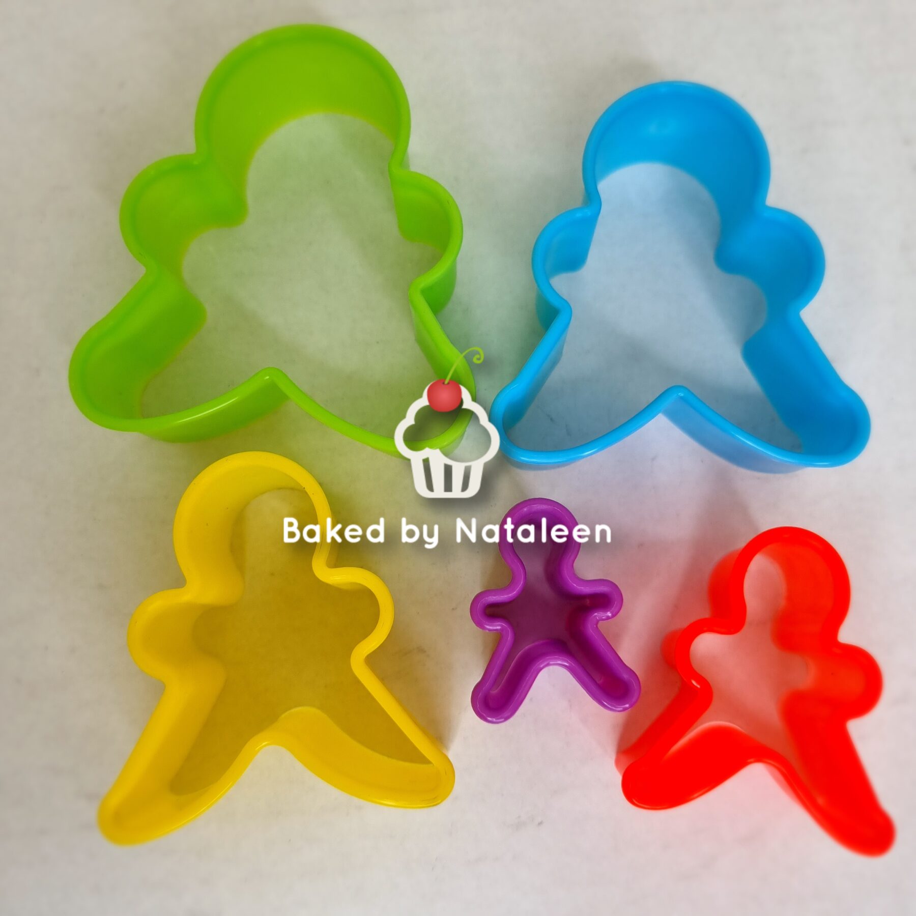 Colorful gingerbread man-shaped cookie cutters in multiple sizes.
