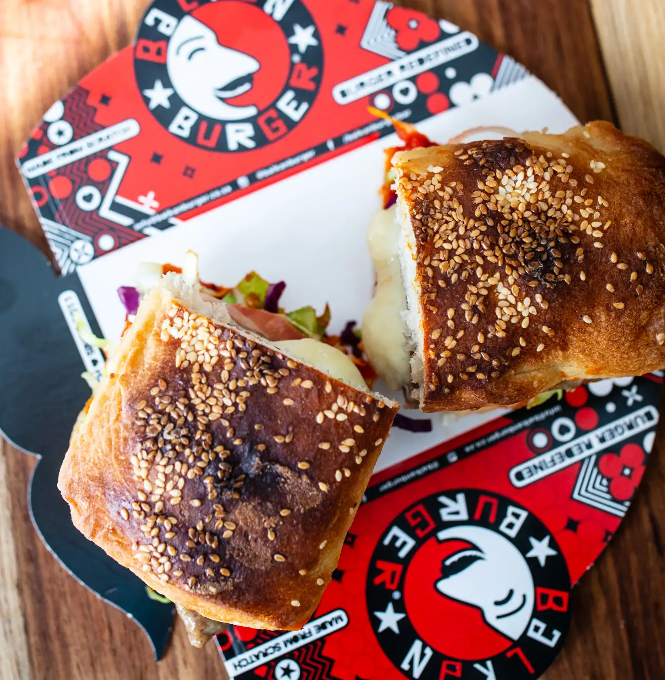 Two gourmet burgers on a branded tray