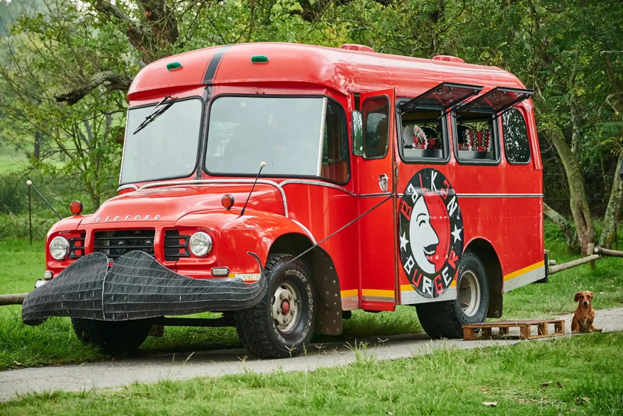 Red Balkan Burger food truck in a green park