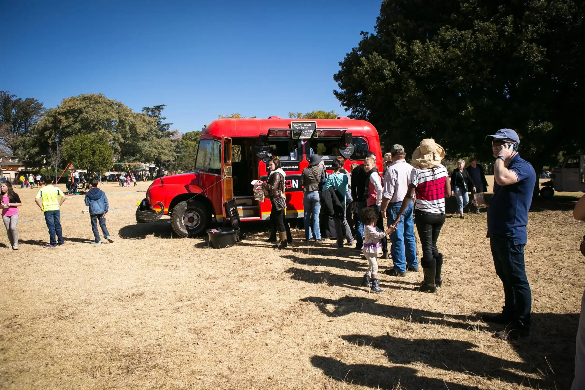 Red food truck with people lining up outside