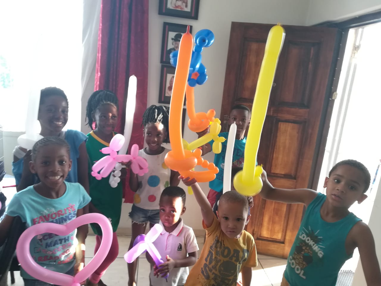 Children holding various colorful balloon creations