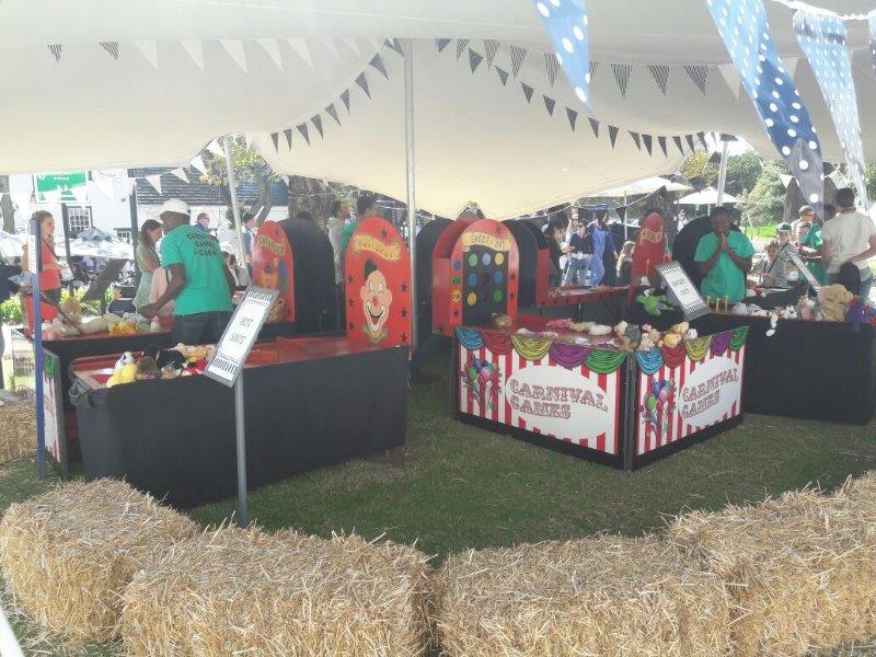 Carnival games setup with colorful booths and players.