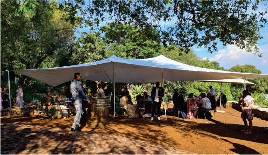 Outdoor tent with guests socializing in a lush environment
