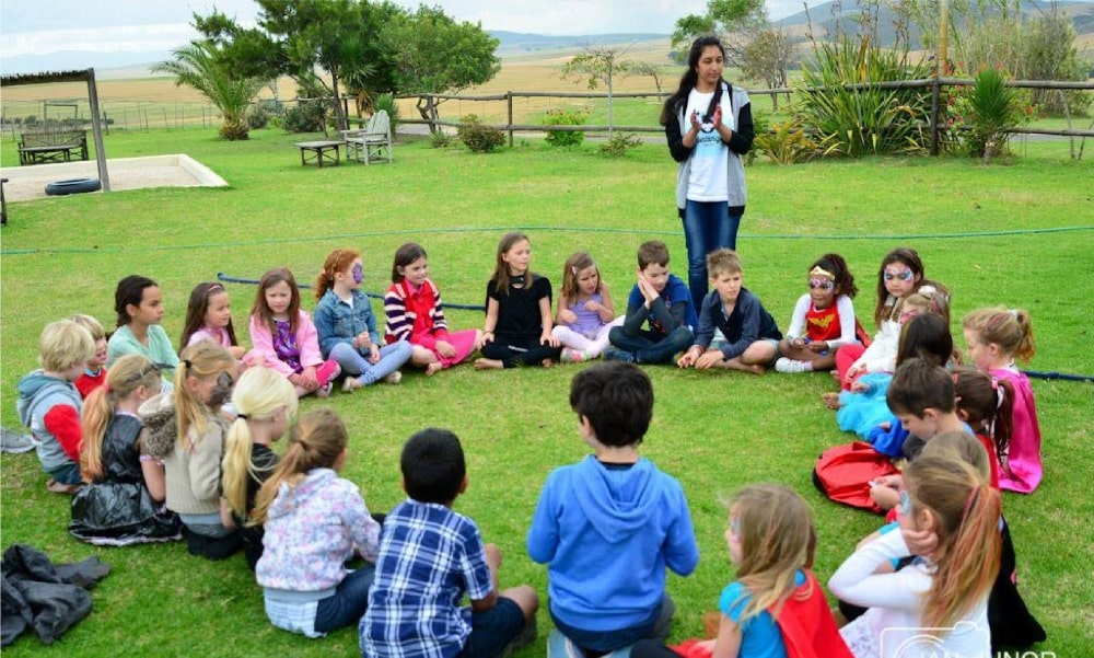 Group of children sitting in a circle during an outdoor activity