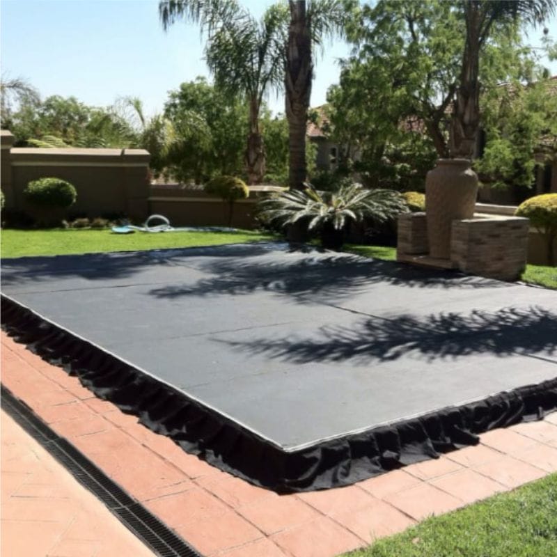 Black event flooring laid out in a garden setting