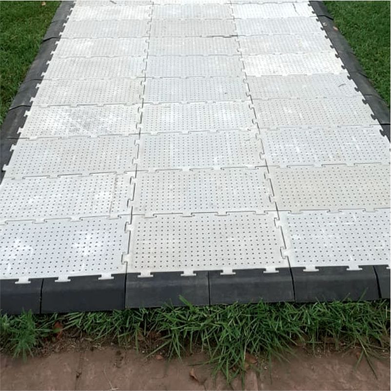 Interlocking floor mats arranged on grass.