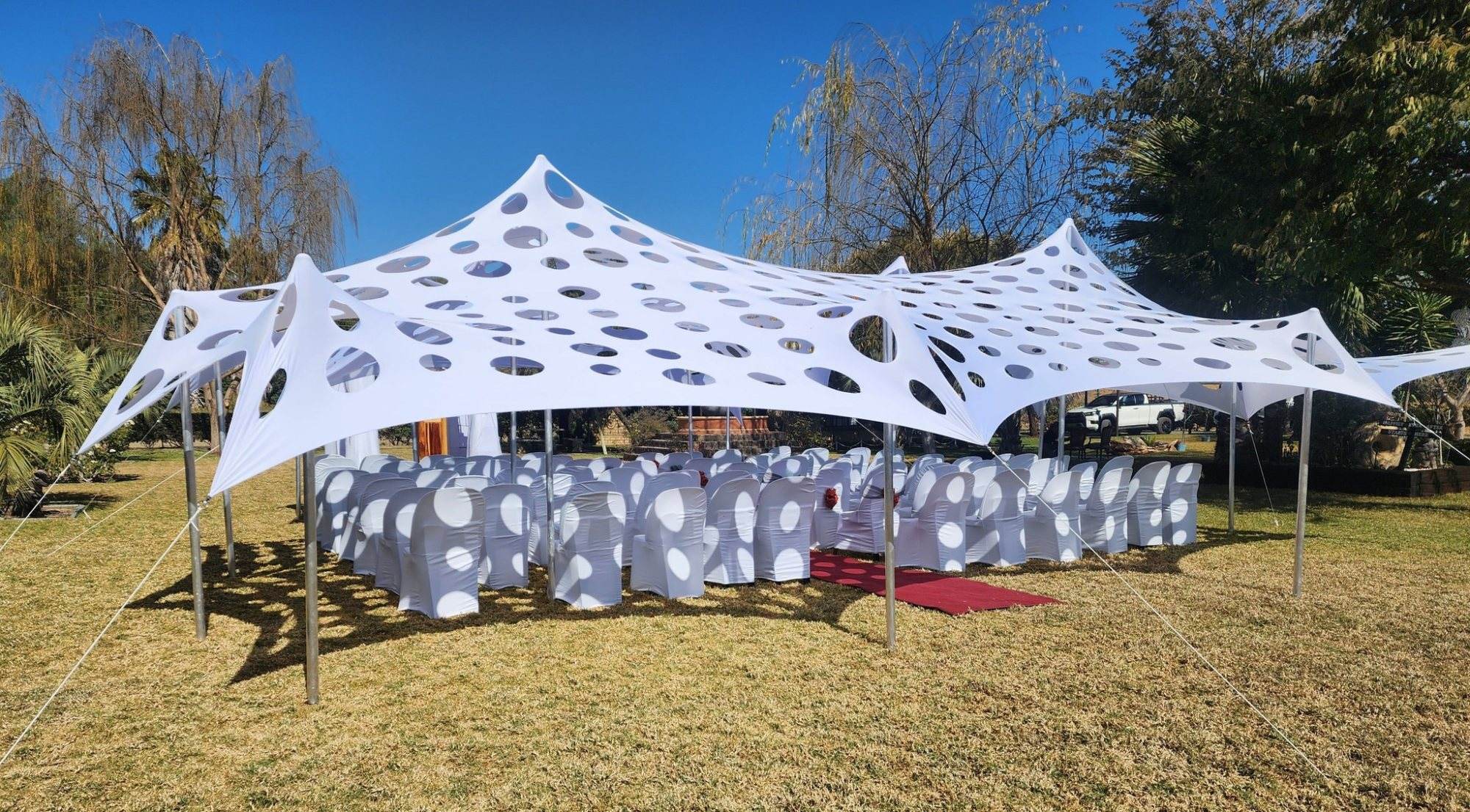 Stylish white canopy with circular cutouts over chairs