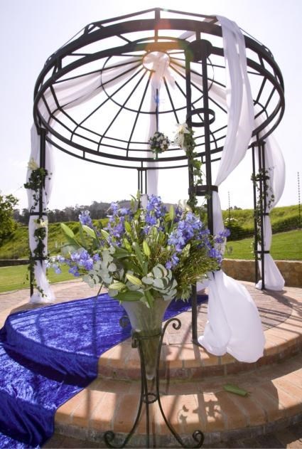 A decorated wedding gazebo with flowers and blue fabric.