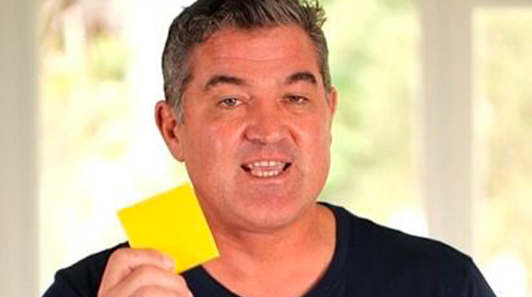 Facilitator presenting a yellow card in a team-building setup.