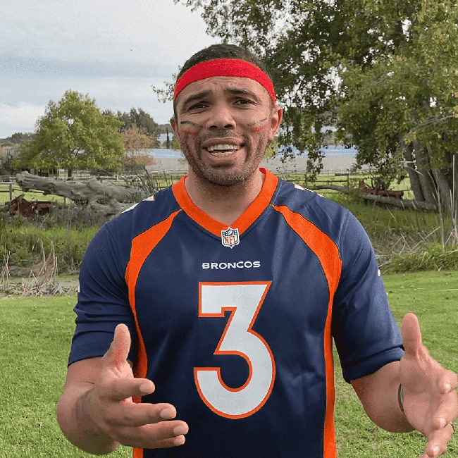 Man in sports gear leading an outdoor team building activity.