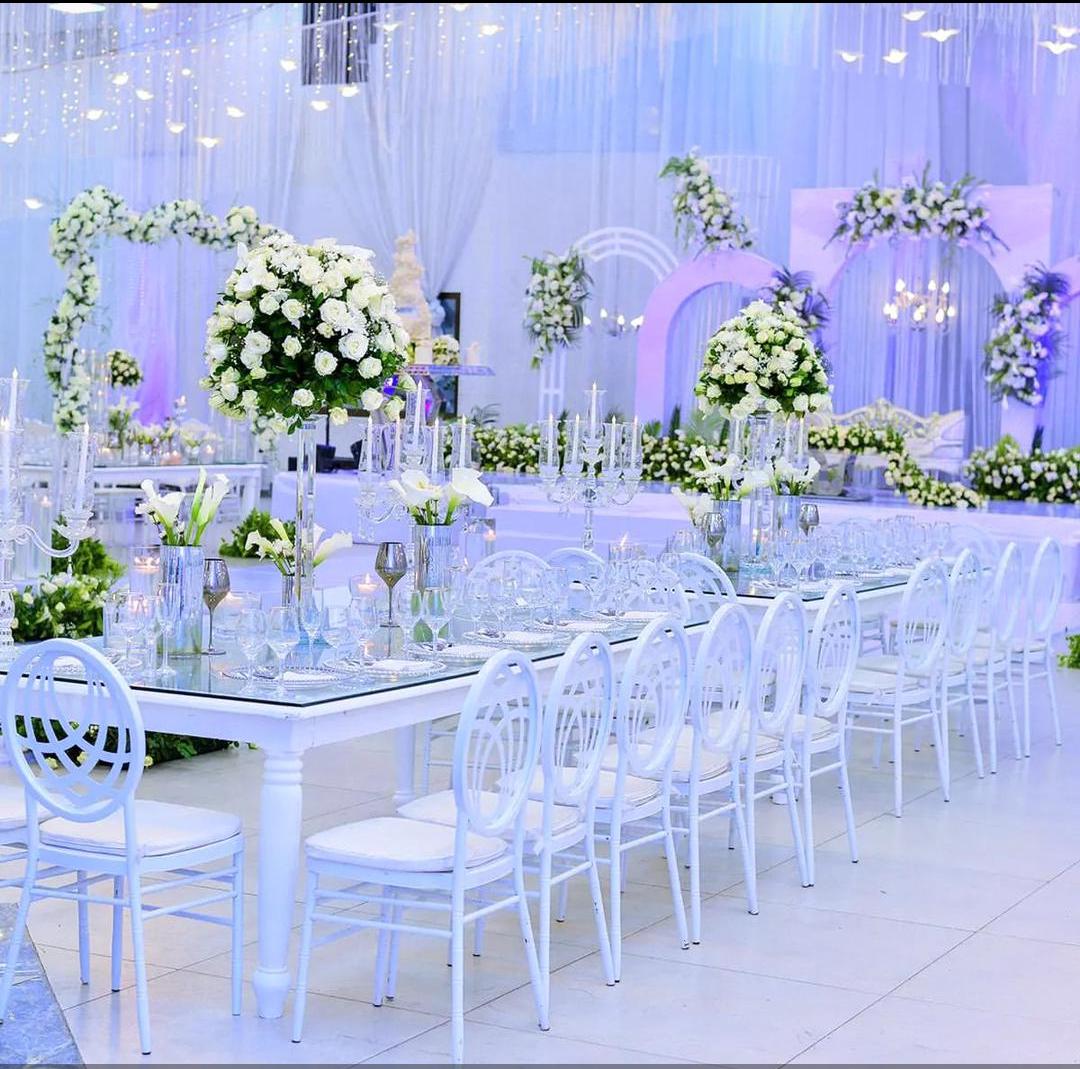 Wedding table with white chairs and floral centerpiece