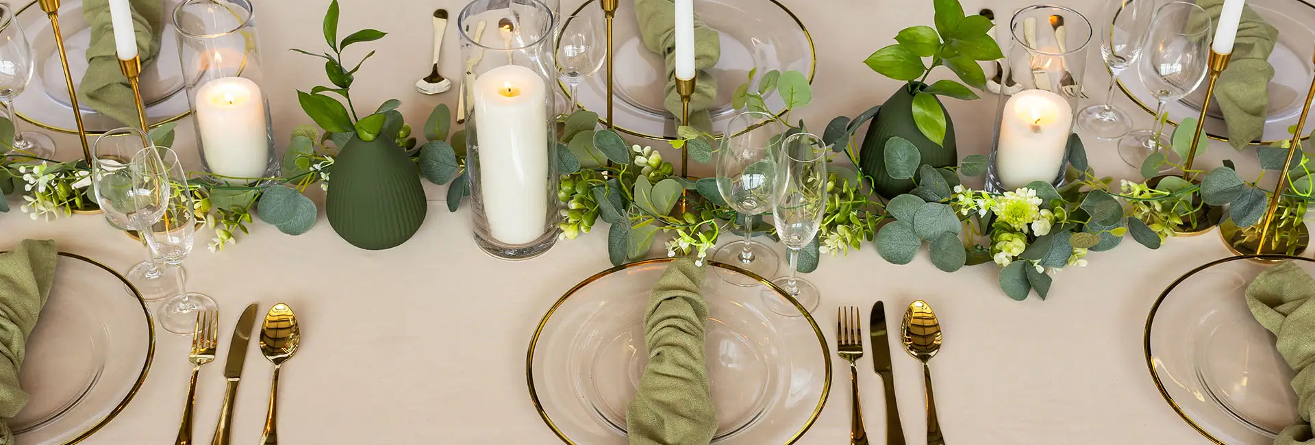 A beautifully set dining table with greenery and candles.