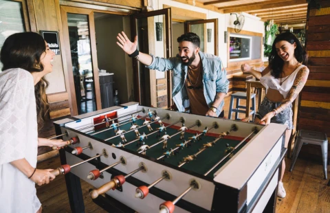 People playing foosball in a wooden venue
