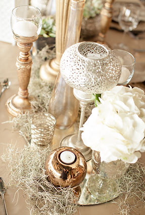 Elegant table centerpieces featuring glass vases and candles