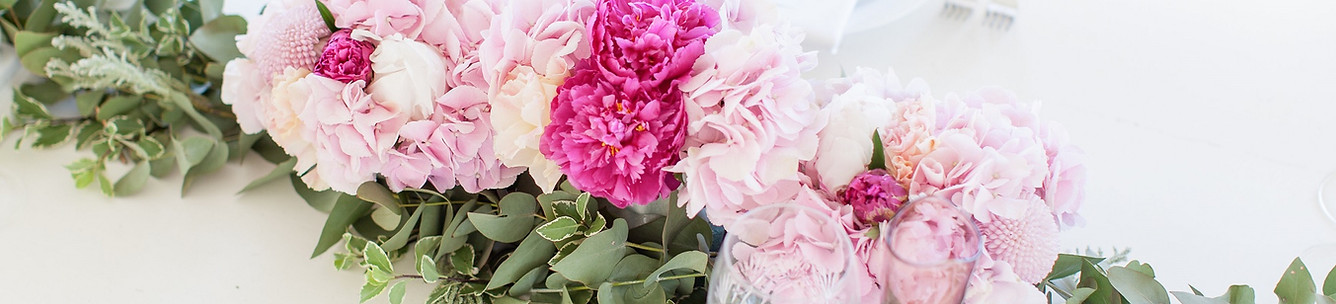 A floral centerpiece made of pink peonies and greenery
