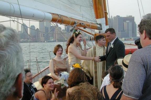 Couple exchanging vows on a sailboat with city skyline