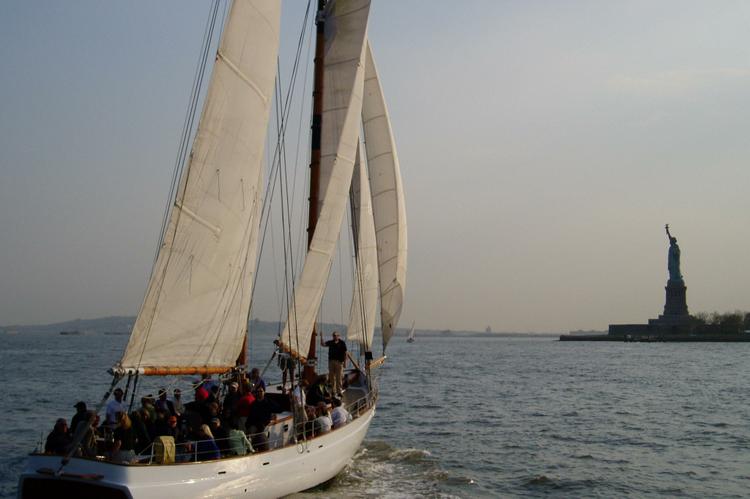 Sailboat with guests passing the Statue of Liberty