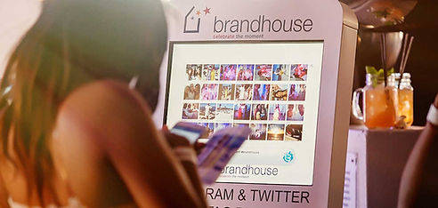 Photo booth display showing images with guests nearby.