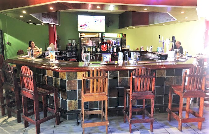 Wooden bar with seating and screens in a vibrant setting