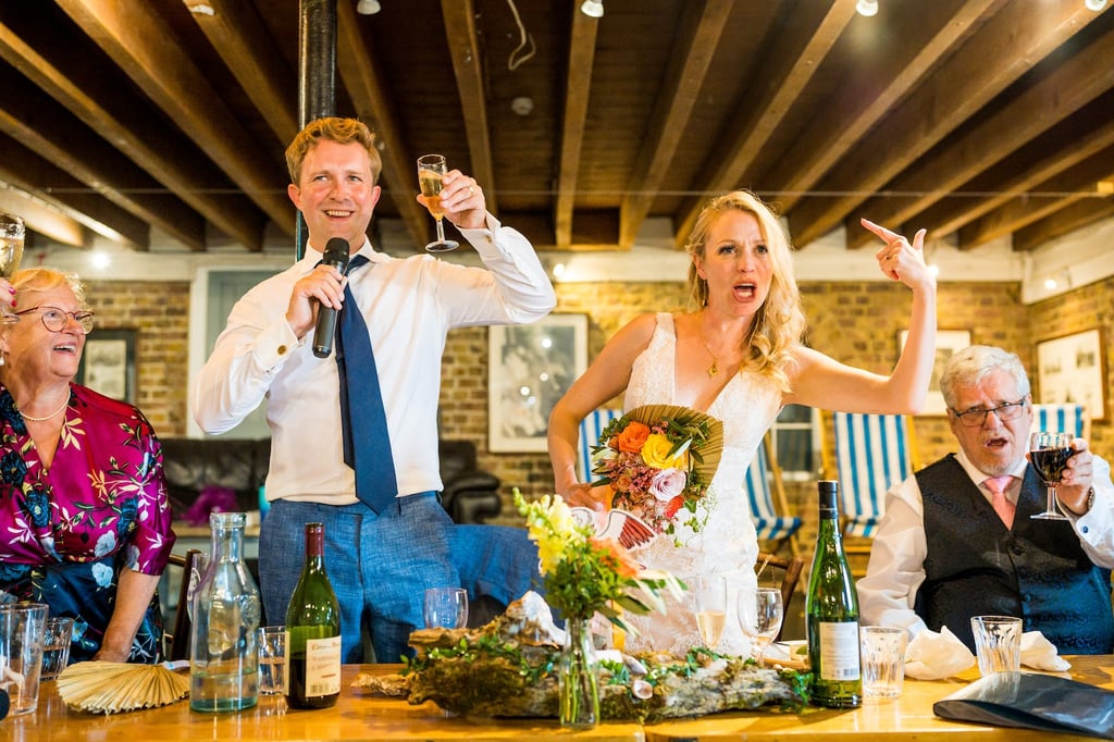 Bride and groom toasting at a wedding in a barn