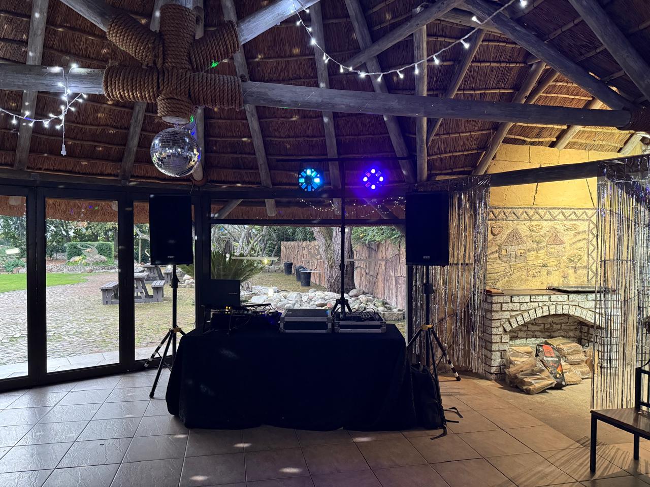 DJ equipment and lighting setup in a rustic venue