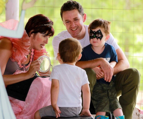 A face painter entertaining children with face paint designs