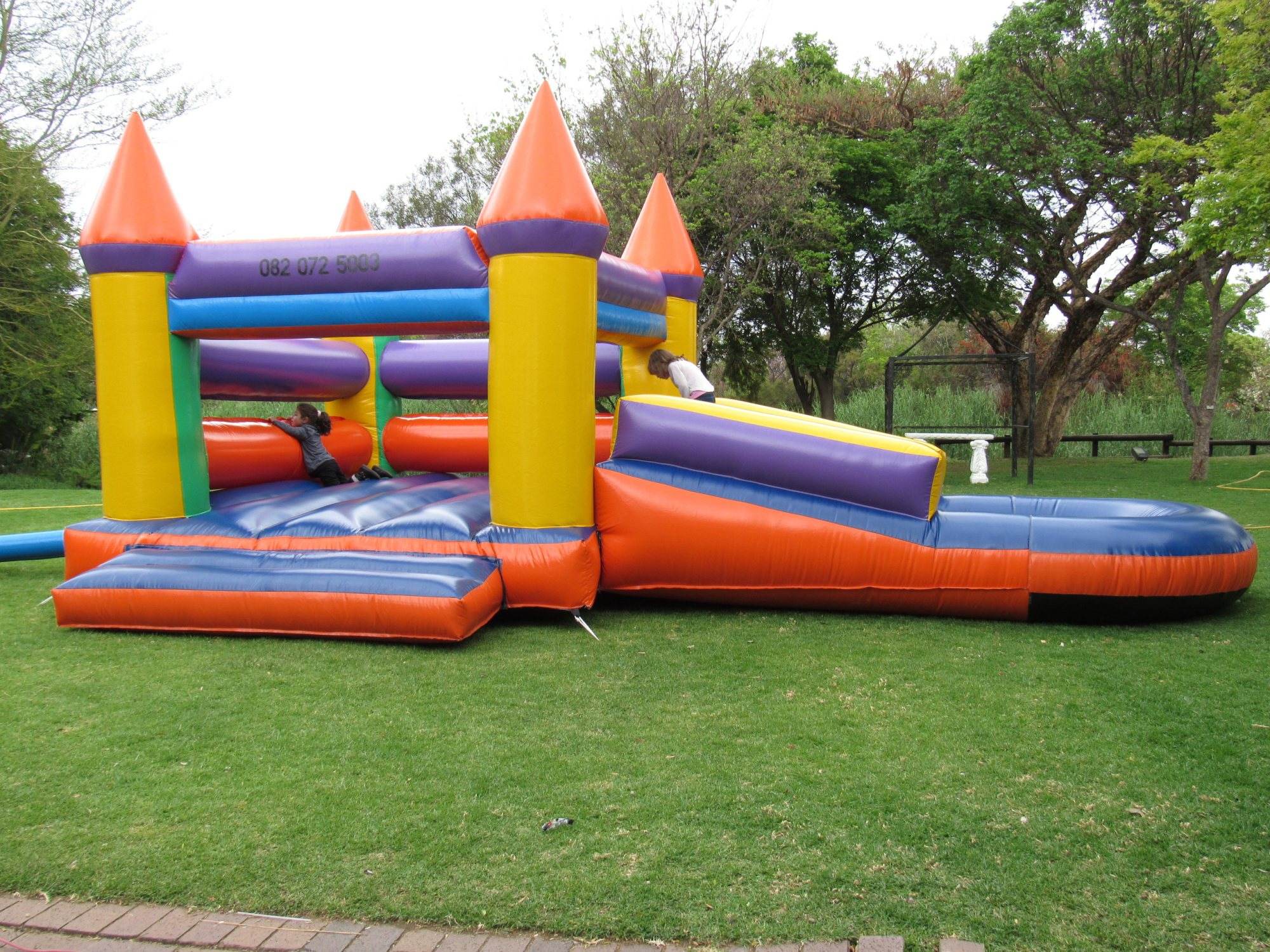 Bright inflatable bouncer with slide on grass