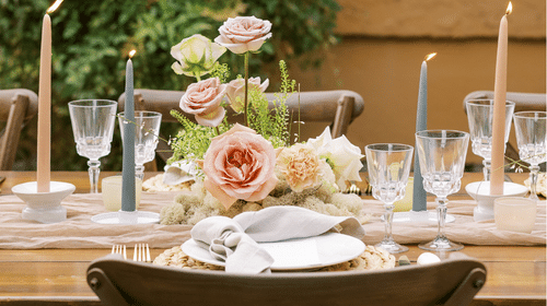 A decorated table with candles and floral arrangements.