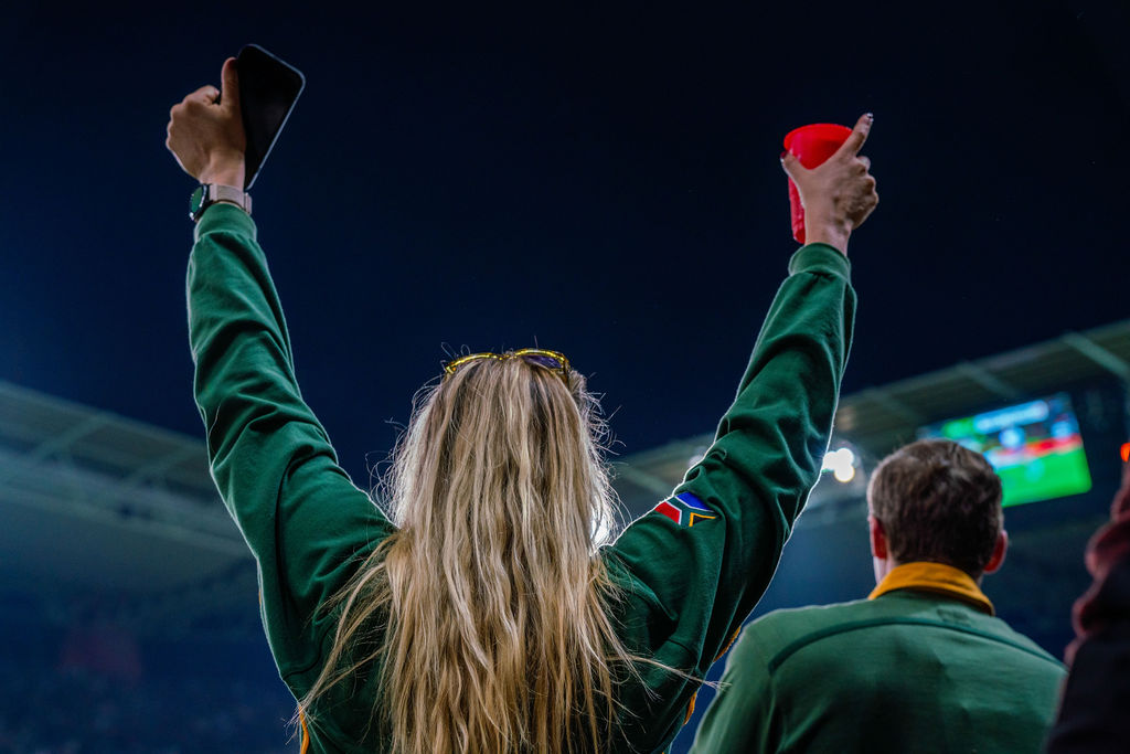 Person celebrating with arms raised at a sporting event