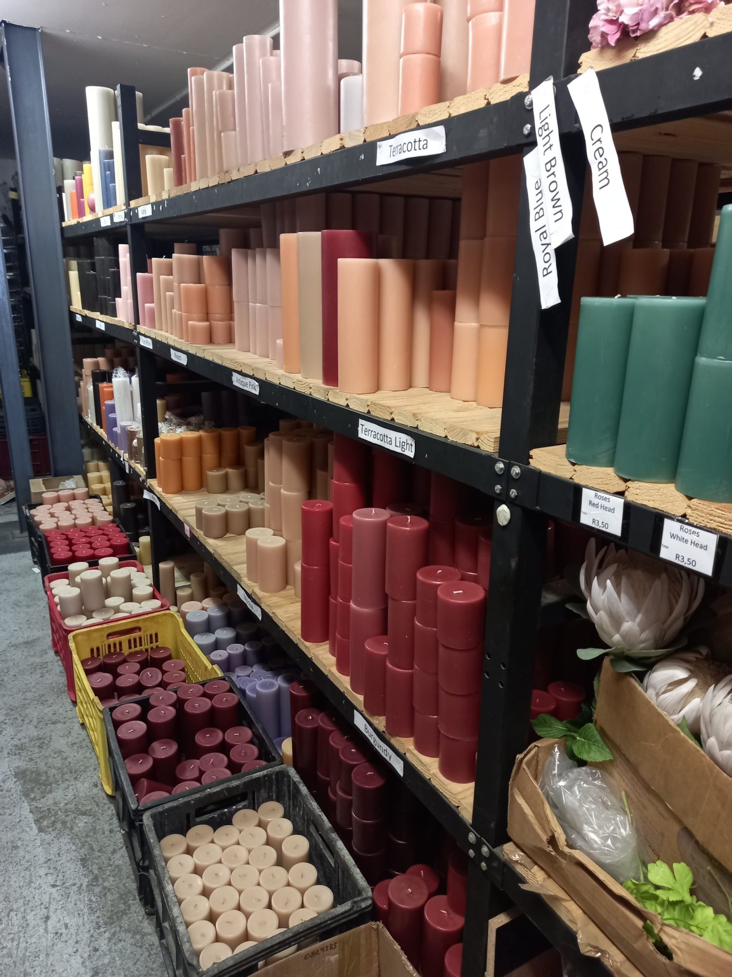 Shelves filled with various colored pillar candles for events