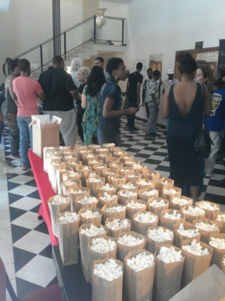 Table with bags of popcorn at an event venue.