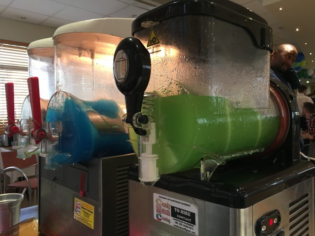 Two slushie machines with blue and green slushie mix.