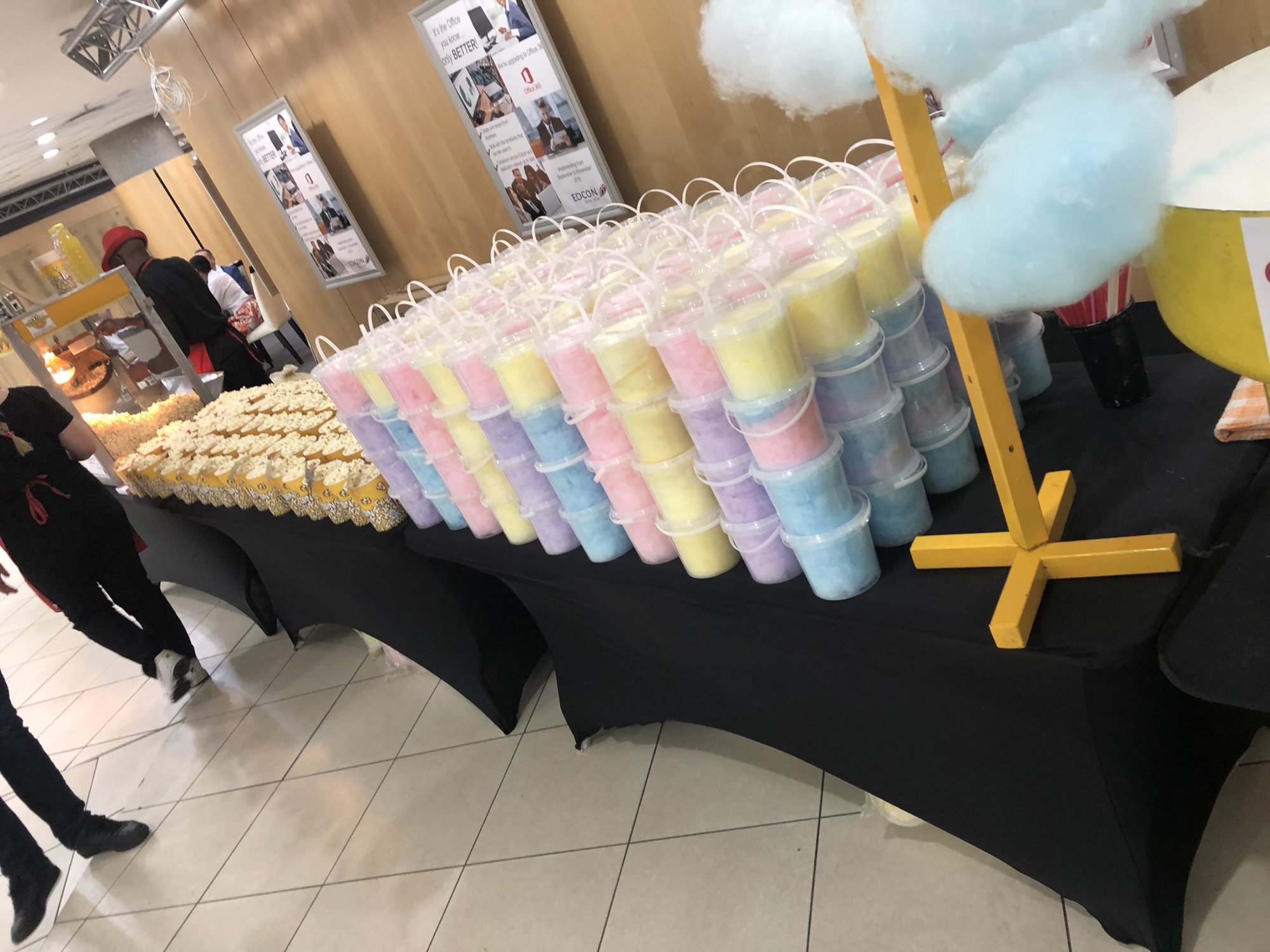 Pastel-colored cotton candy tubs on a black table.