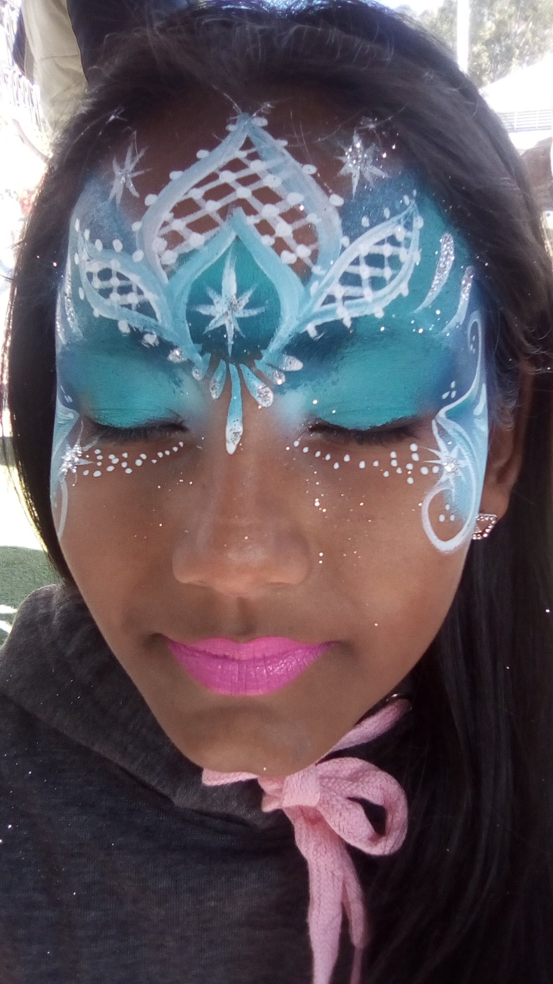 Girl with blue and white face painting design.