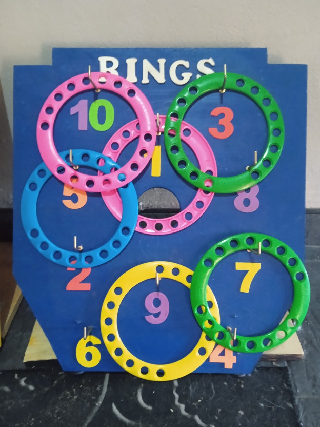 Ring toss game with colorful rings on a blue board.