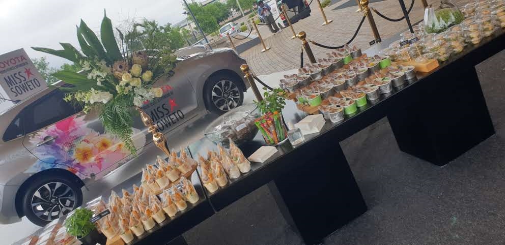 Catering table with assorted finger foods and desserts.
