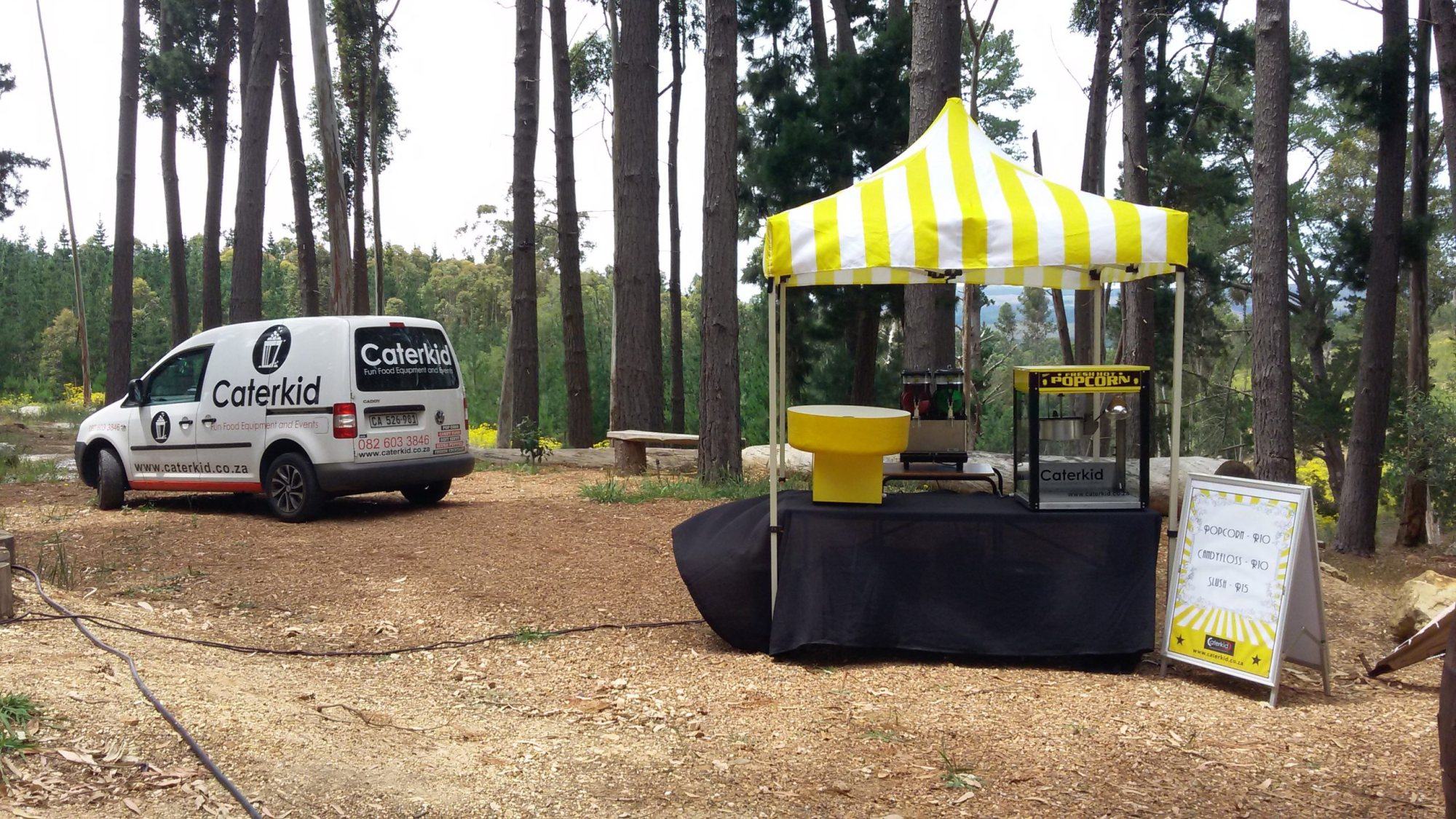 Popcorn machine setup with a service vehicle in a forest clearing